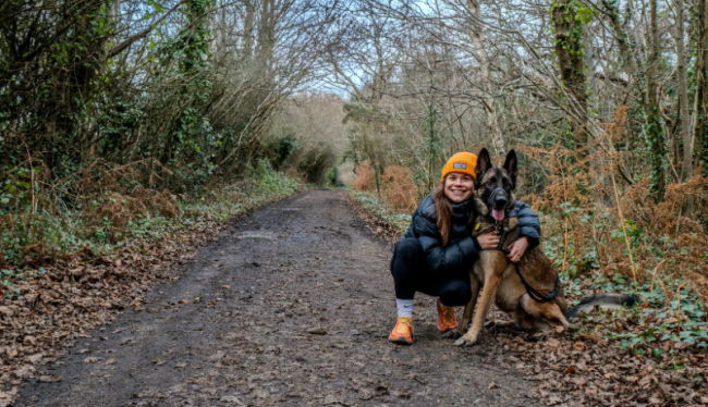 vrouw met muts in een bos met een herder