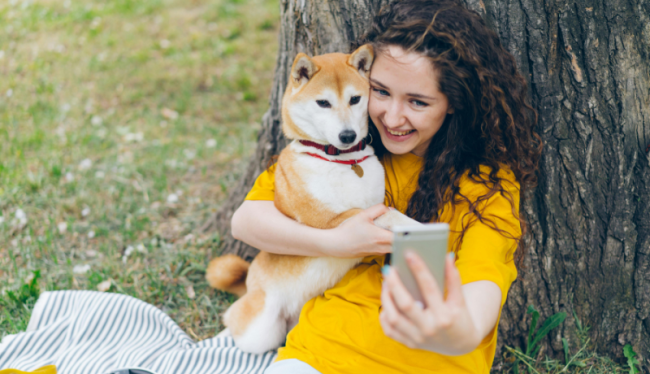 Oppas neemt een selfie met een shiba inu